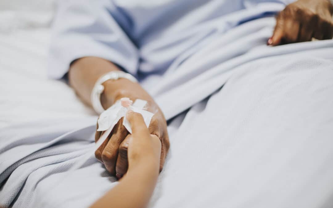 Patient hand with IV, comforting hold in hospital.