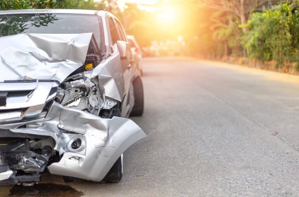 Damaged car on sunny road in daytime